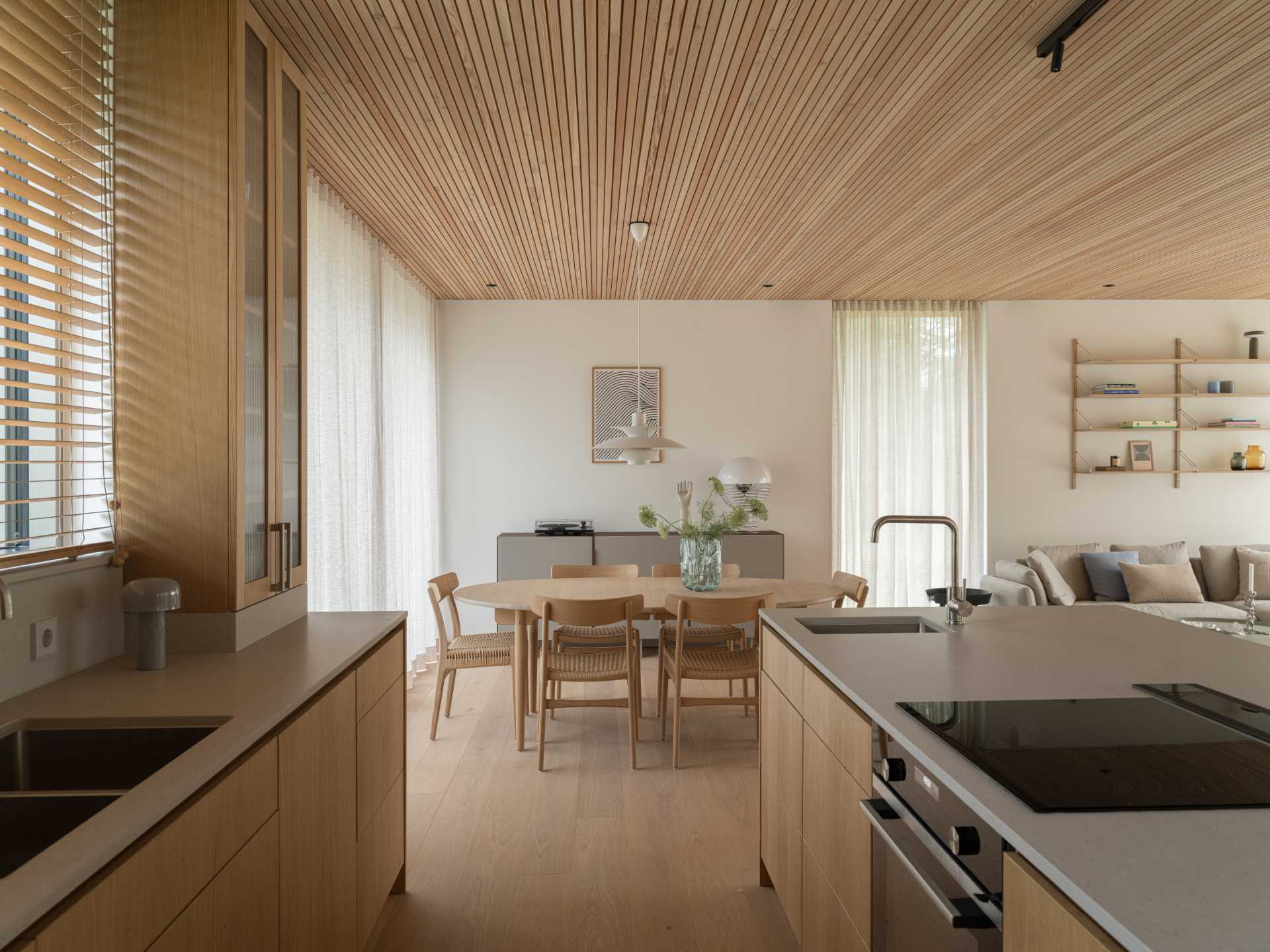 The living room, dining area, and kitchen are all open plan, with the wood kitchen cabinets complementing the wood found throughout the home.