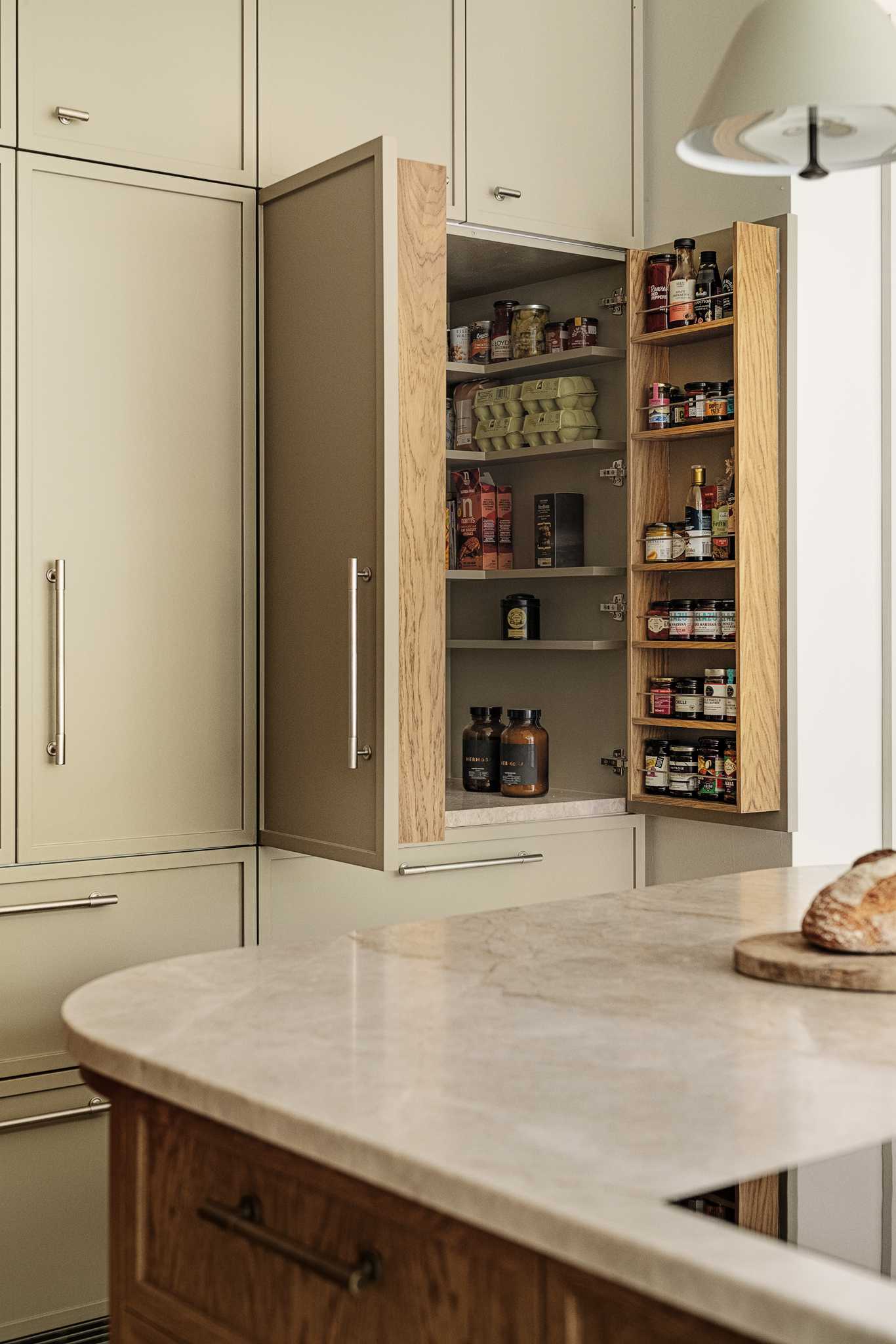 What was once the living room is now the new kitchen. A doorway was closed off to create additional space for kitchen cabinets and countertops, while the kitchen island with a wood front curves to make room for seating.