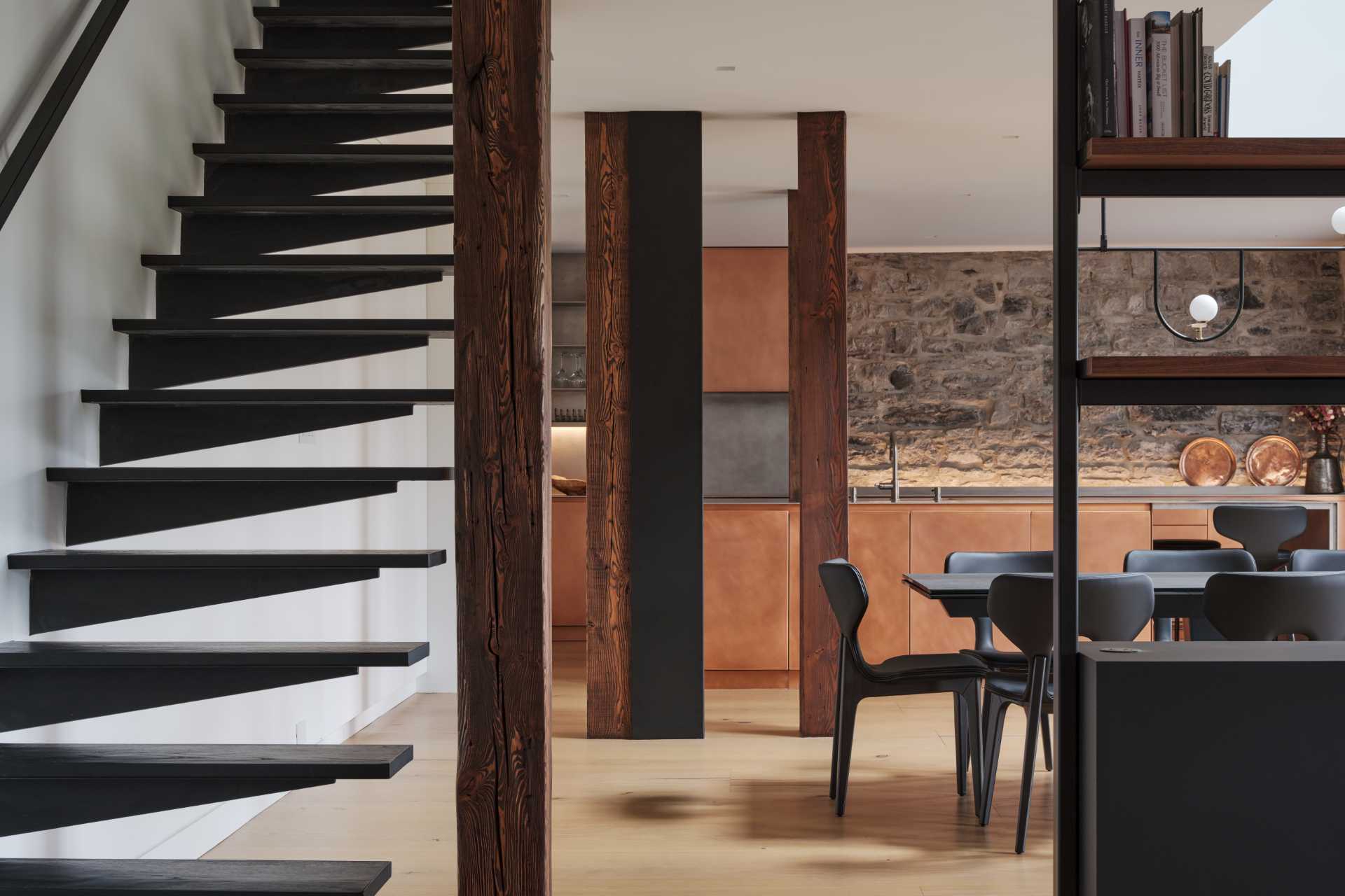 Wide oak planks and a sculptural black-metal staircase enhance the sense of grandeur in this loft apartment.