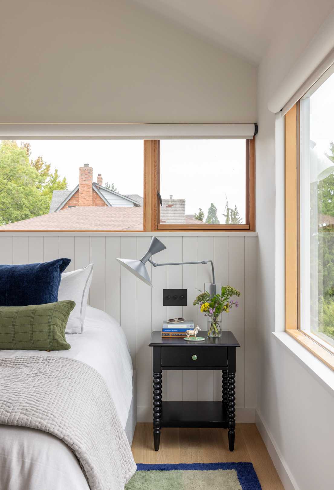 A contemporary bedroom with wood window frames.