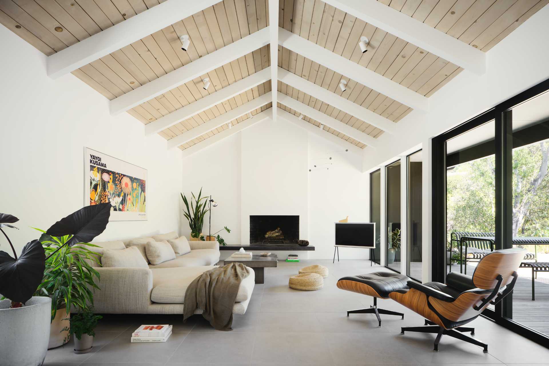 The restored wood ceiling in the living room accompanies clean white walls, creating visual ties to the custom wood kitchen cabinets and the sculptural wood screen that delicately demarcates the living room from the entryway.