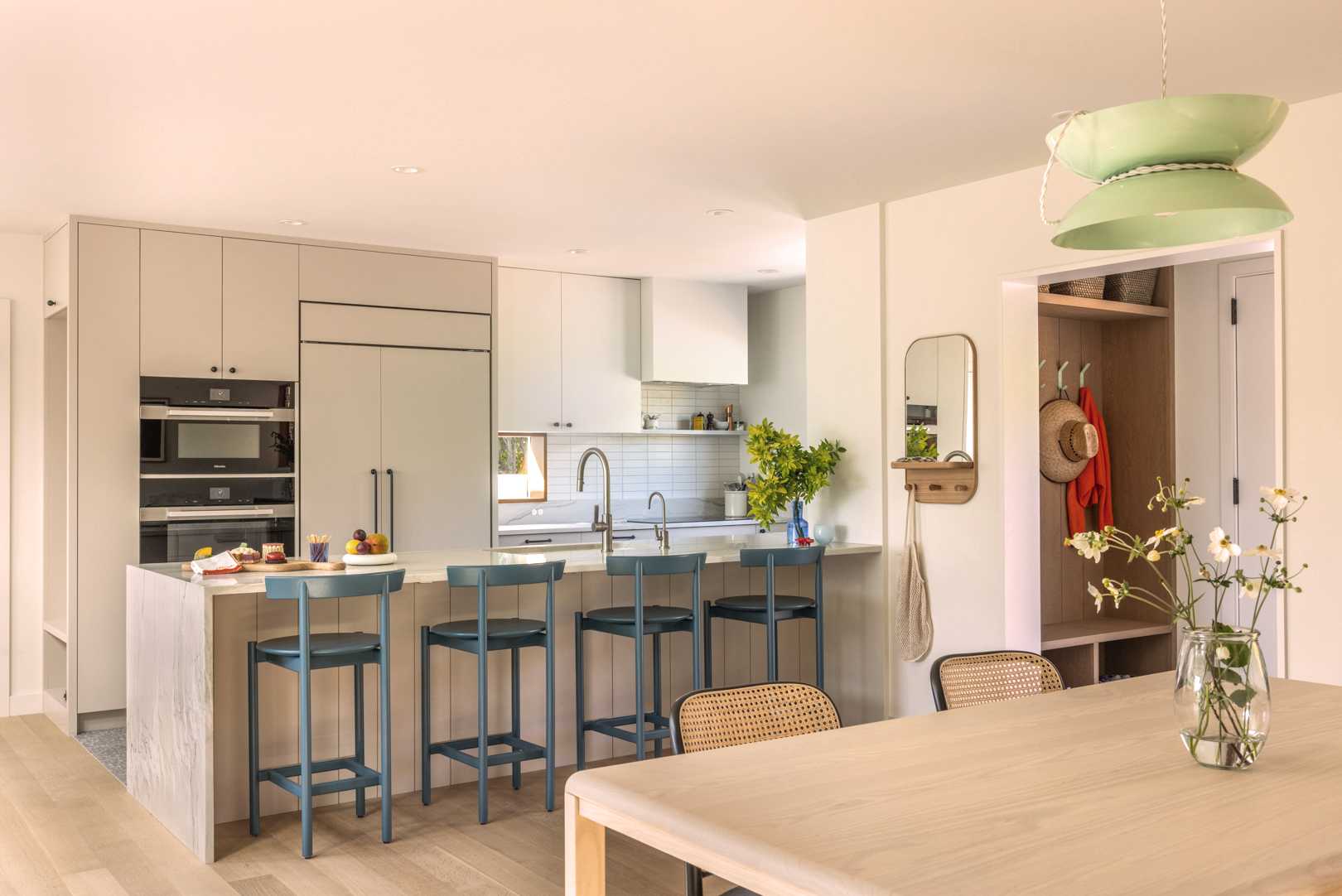 This new kitchen features a functional “U” shape with natural stone countertops, offering seamless access to the dining and living areas for a connected main floor experience.