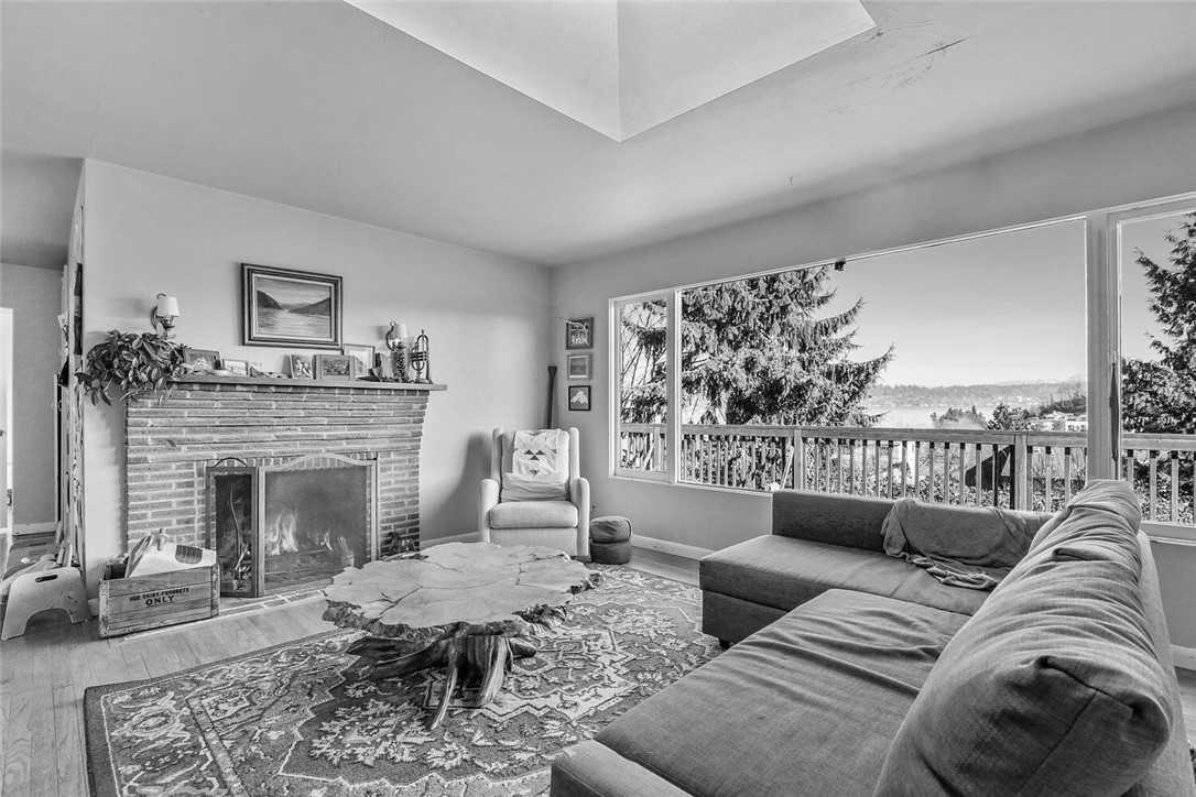 Before - a dated living room with picture window and fireplace.