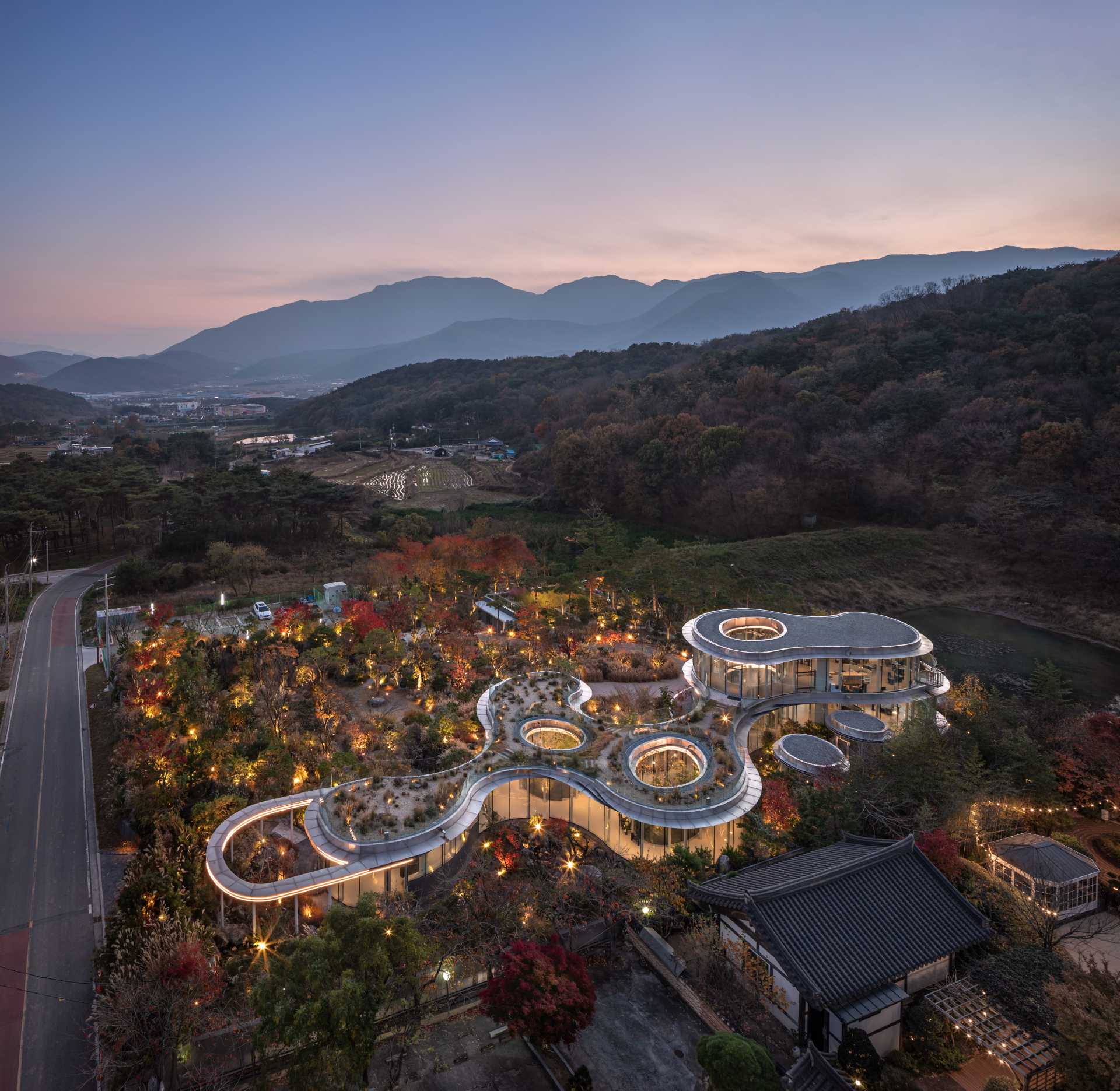 A modern cafe in South Korea, with social spaces and a green roof, was inspired by a walk in the forest.