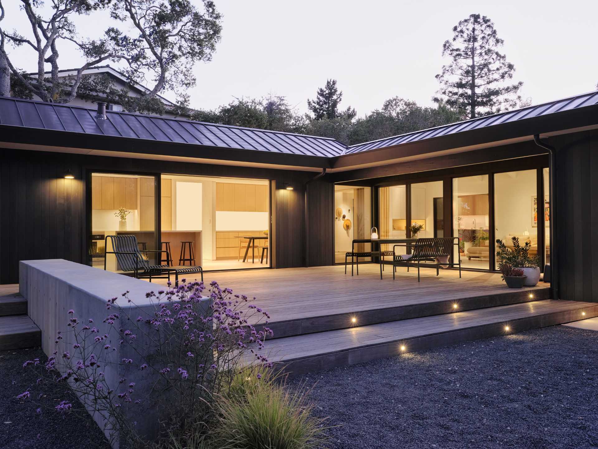 In the rear yard, an old patio and plain backyard was replaced with concrete walls that create two distinct, layered outdoor living spaces, emphasizing the new modern aesthetic and adding structure to the experience of the site and architecture.