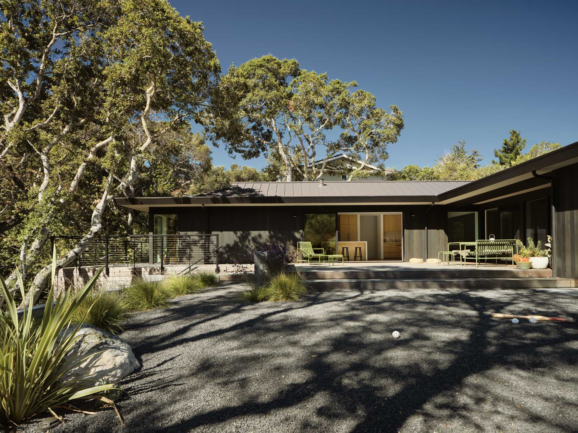 In the rear yard, an old patio and plain backyard was replaced with concrete walls that create two distinct, layered outdoor living spaces, emphasizing the new modern aesthetic and adding structure to the experience of the site and architecture.