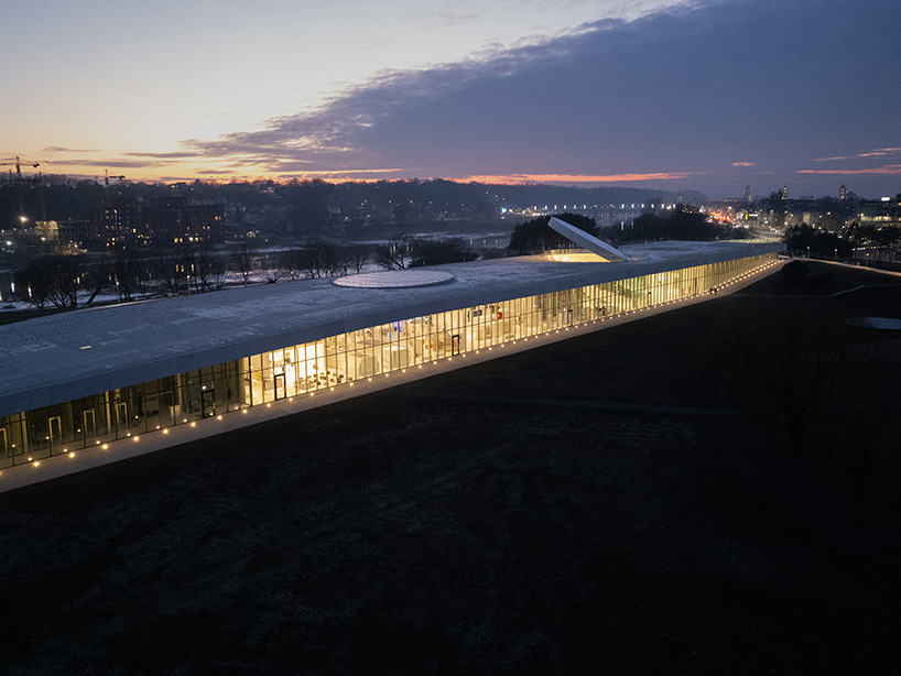 tilted reflective disk sits atop SMAR's science island museum in nemunas, lithuania
