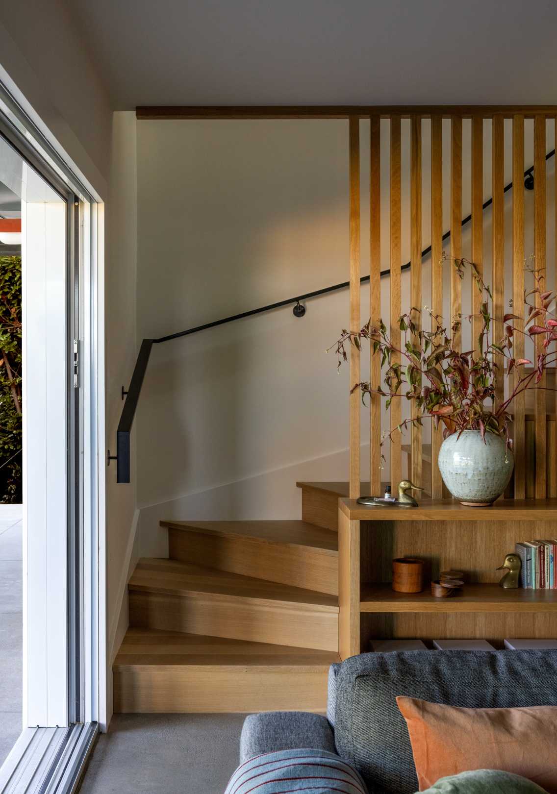 A updated interior with wood stairs and built-in shelving.