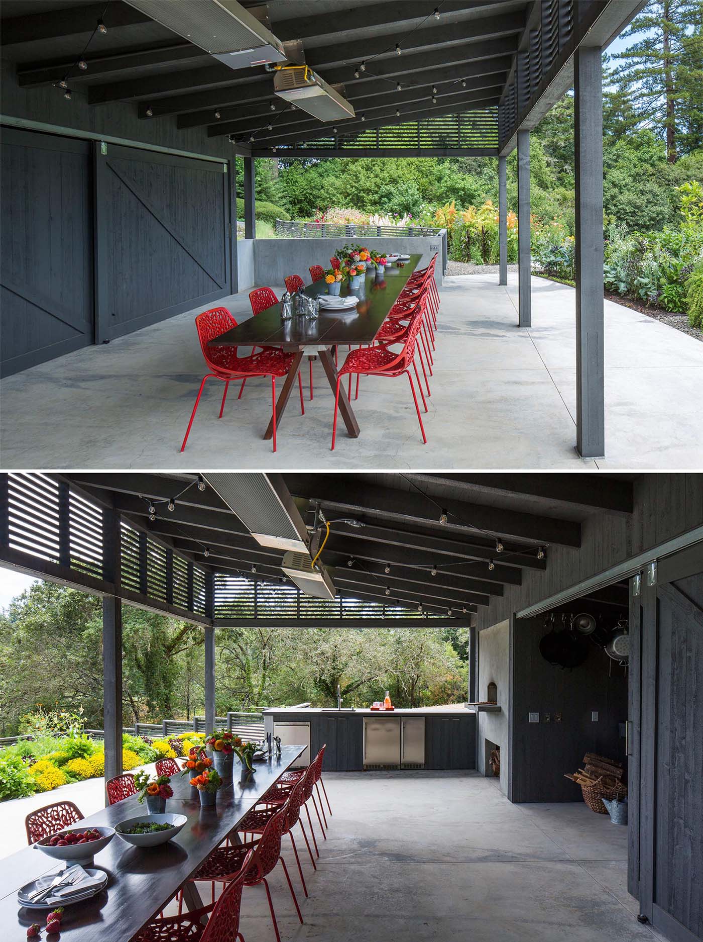 This inviting outdoor dining space features a long, table paired with modern red chairs, offering a perfect setting for gatherings. A built-in wood-fired oven adds a touch of warmth and functionality, making it ideal for cooking and entertaining. The terraced garden design adds depth to the space, while clean stone steps lead to different levels, creating a sense of privacy and tranquility. With thoughtful lighting and natural materials, this dining area offers both comfort and charm. 