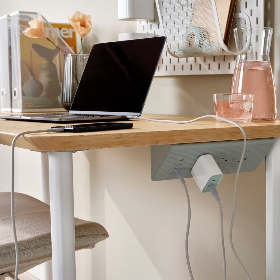 IKEA SKOTAT extension cord hung under a desk