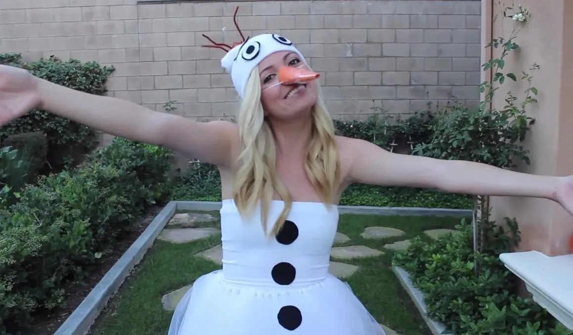 Woman in a snowman costume with a playful pose.