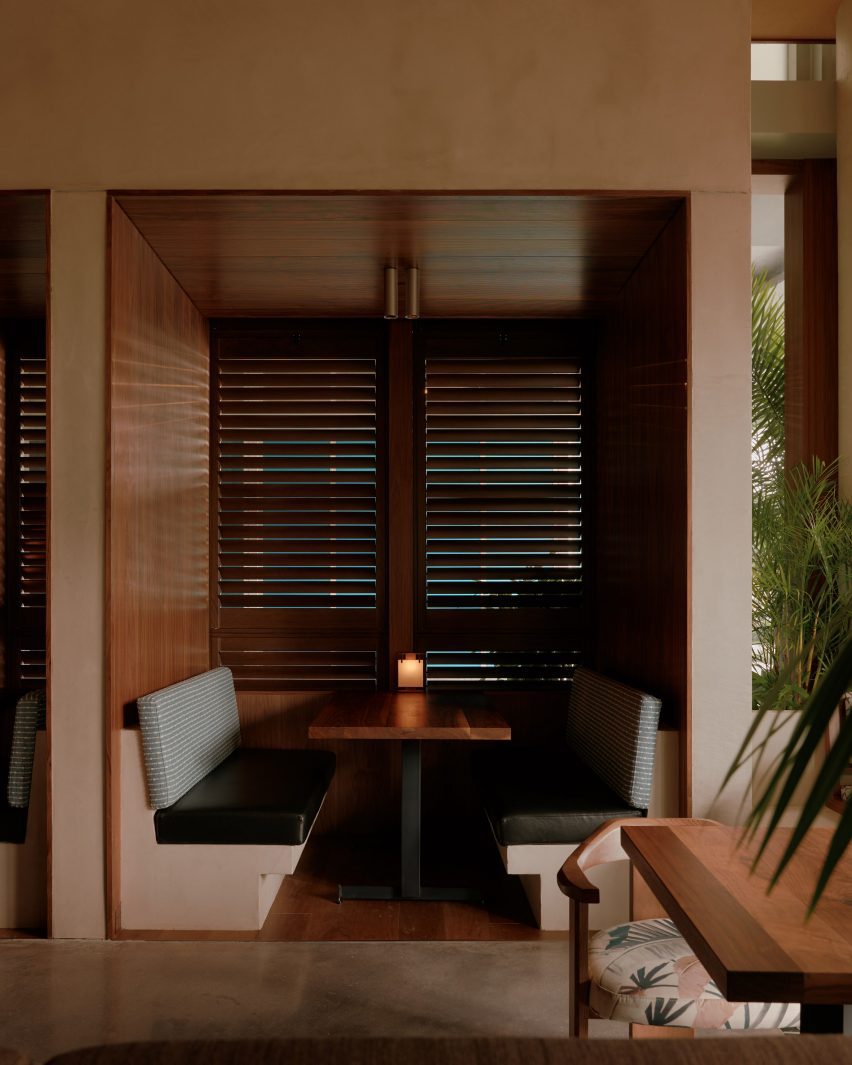 Booths set into a teak-wrapped niche with louvred shutters behind