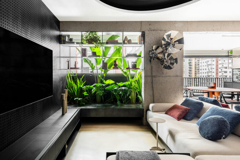 A room with a white couch and a black tv.