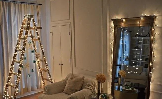 Cozy living room decorated with string lights and a ladder.