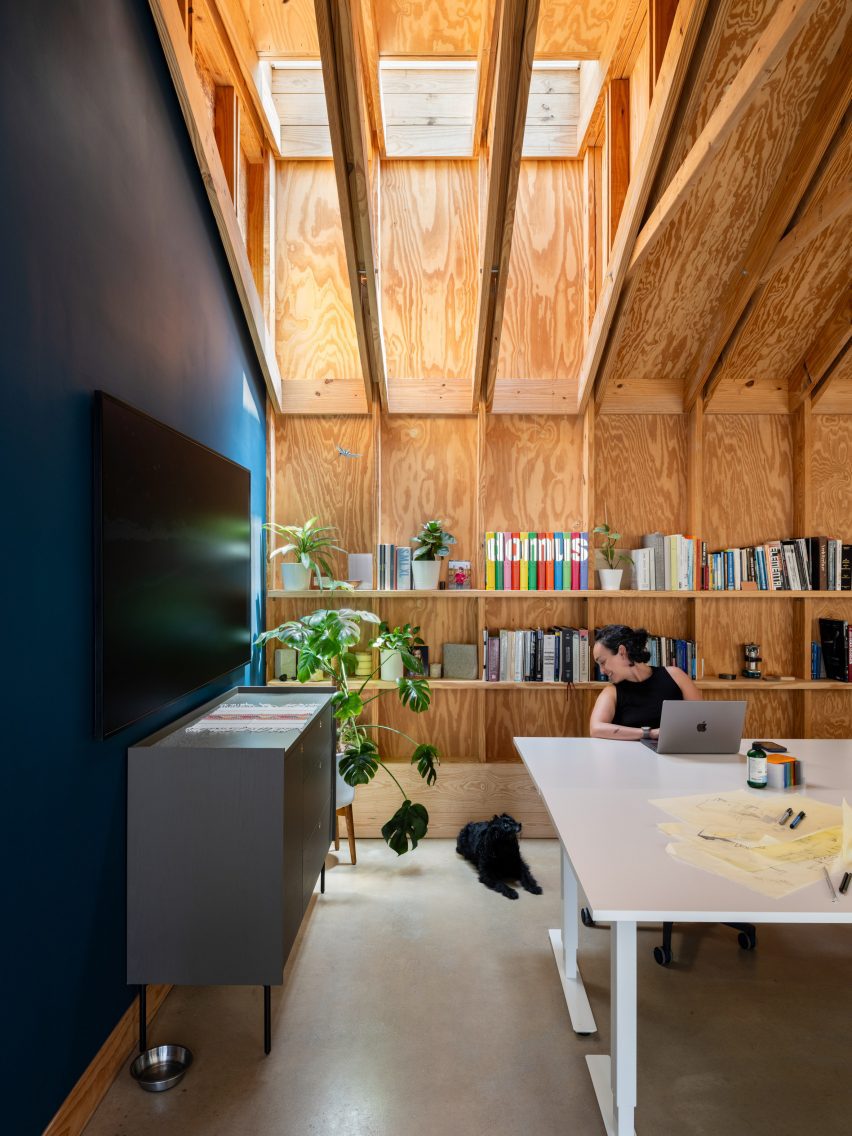 Architect's studio with a skylight above and shelves behind a white desk