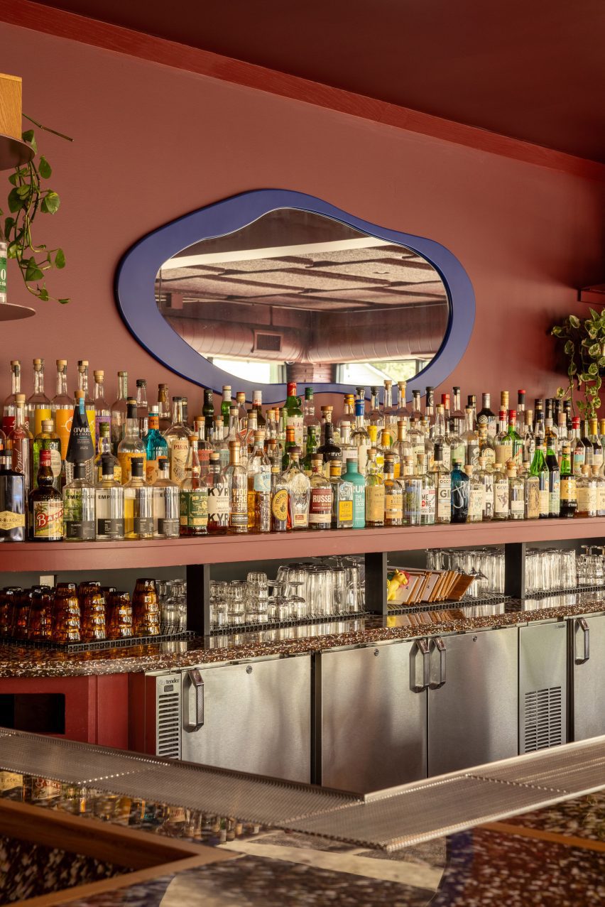 Fully stocked bar with a blue-framed mirror above