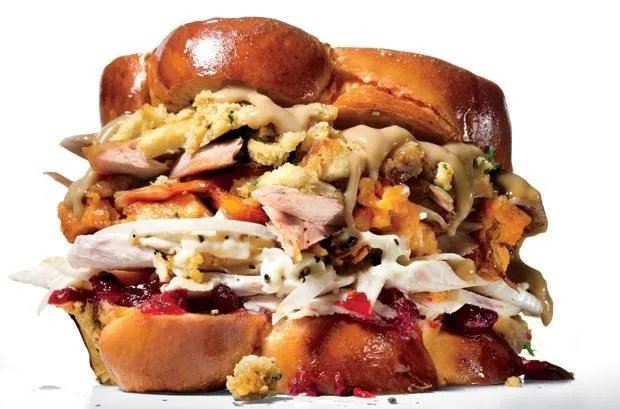 Thanksgiving sandwich with turkey, stuffing, and cranberry sauce on a brioche bun.