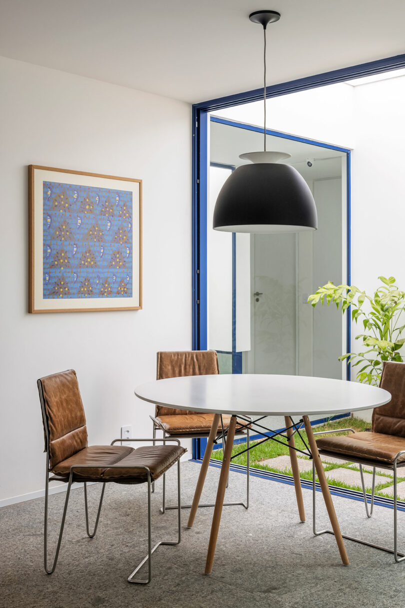 corner view of cafe table with three chairs by window wall