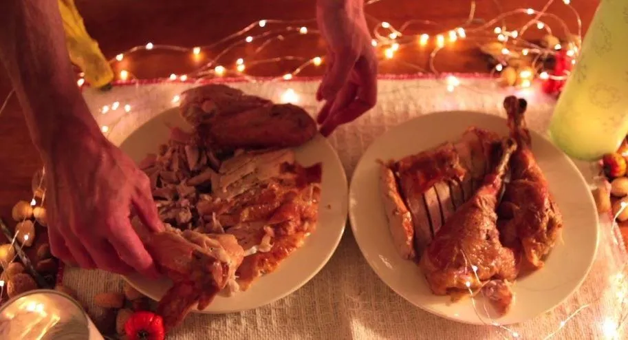 Thanksgiving turkey dinner being served on festive table.