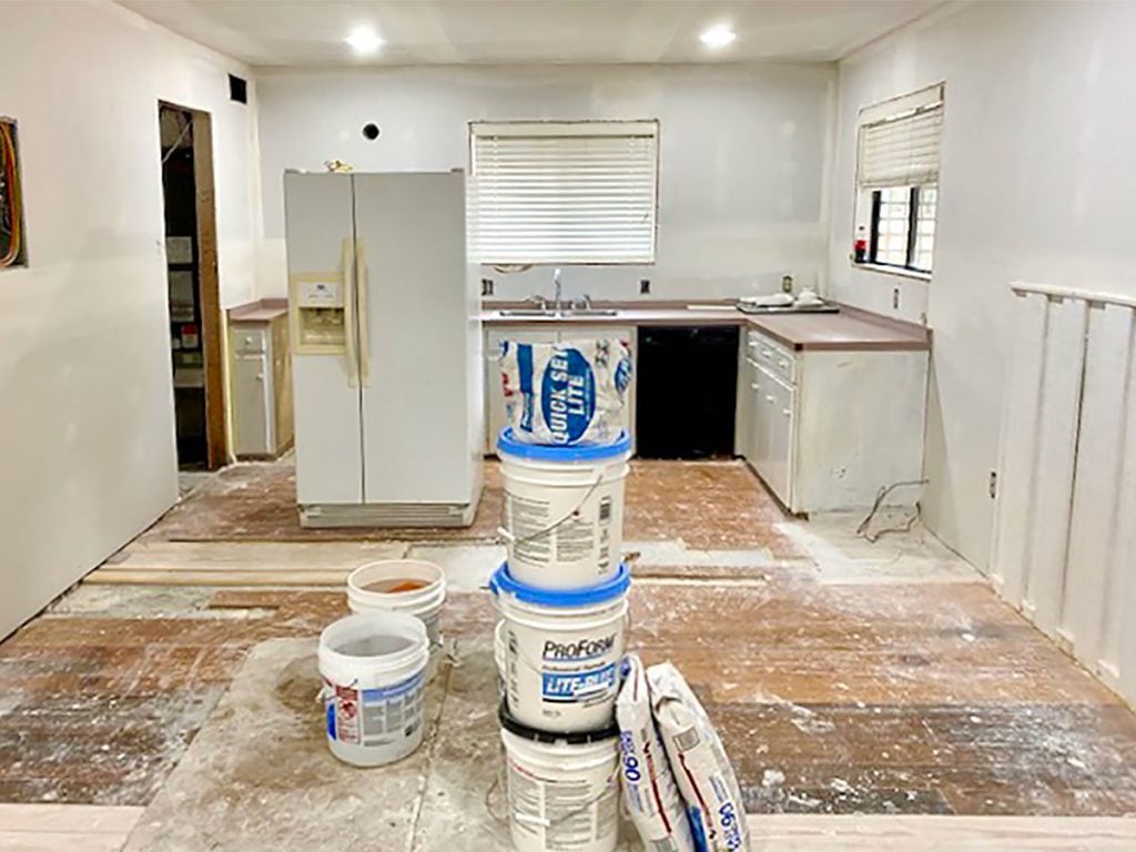 Kitchen Renovation With Dusty Floors And Refrigerator In The Middle Of The Room