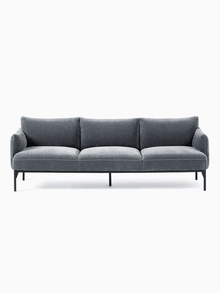 Blue-grey velvet three-seat couch with armrests and straight black legs