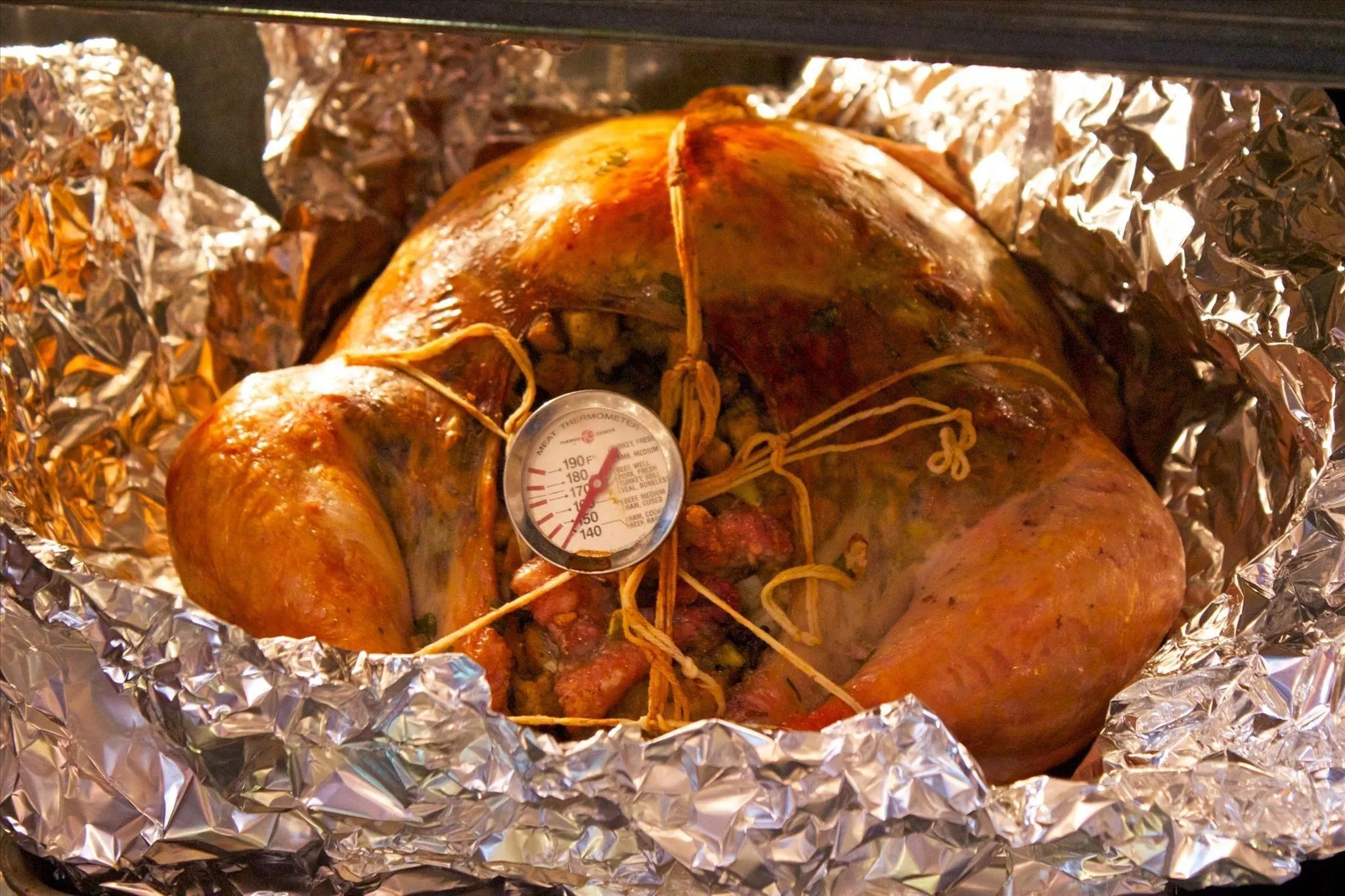Roast turkey with a meat thermometer in the oven.