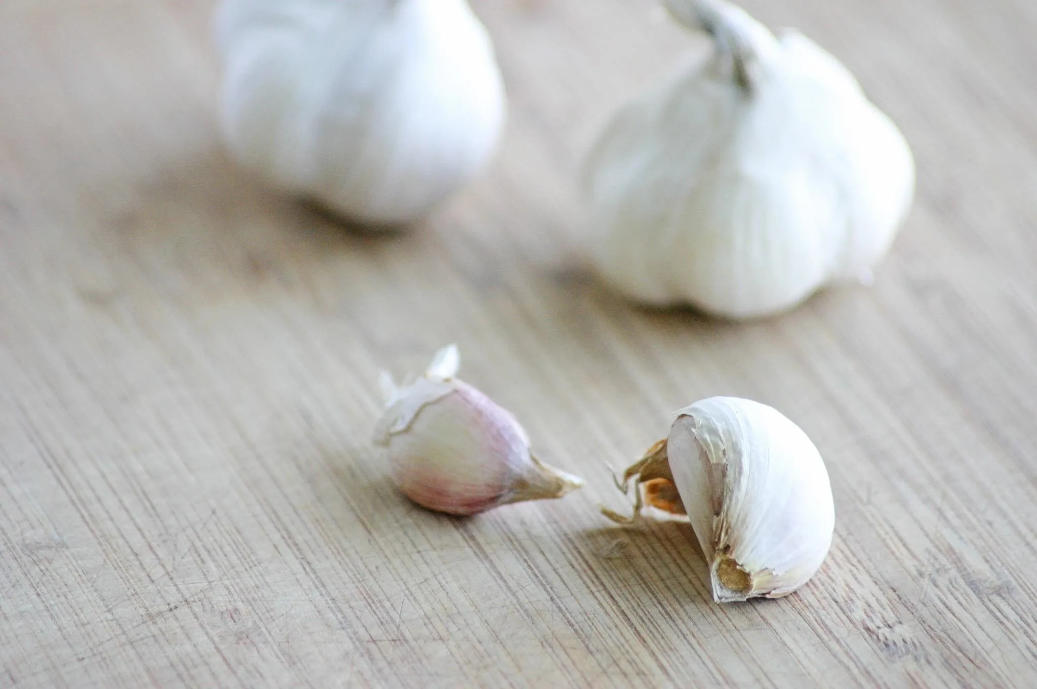 Fresh garlic cloves on a wooden surface.